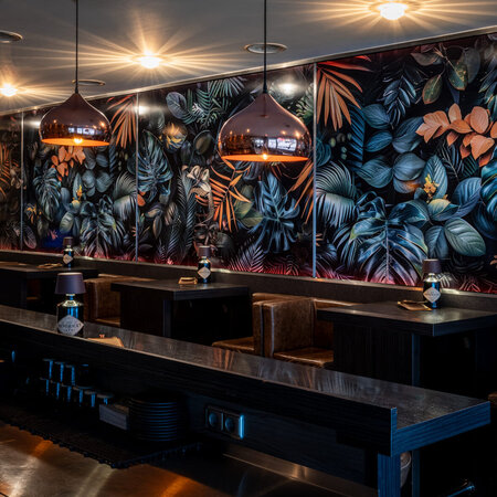 Stylish seating area with tropical wall design and atmospheric lighting